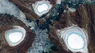 Three ice caps with white tops and blue rings around their edges, each on an island seperated by a narrow stretch of sea